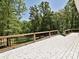 Large backyard deck area with wooden railing offering peaceful views of nature at 124 Canterbury Ln, Matthews, NC 28104