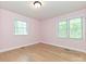 Bedroom featuring hardwood floors and natural light from two windows at 124 Canterbury Ln, Matthews, NC 28104