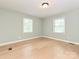 Empty bedroom showcasing hardwood floors and natural light from two windows at 124 Canterbury Ln, Matthews, NC 28104