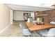 Open dining area with seating for four and a living room featuring an exposed brick fireplace at 124 Canterbury Ln, Matthews, NC 28104