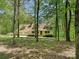Exterior showcasing a yellow two-story home surrounded by trees, with an attached garage and inviting front porch at 124 Canterbury Ln, Matthews, NC 28104