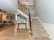 Foyer features wooden floors, staircase with an iron banister and the living room is in the background at 124 Canterbury Ln, Matthews, NC 28104