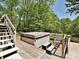Exterior deck view featuring a hot tub and seating, surrounded by lush trees at 124 Canterbury Ln, Matthews, NC 28104
