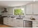 Bright kitchen features sleek countertops, stainless steel appliances, and a large window overlooking lush greenery at 124 Canterbury Ln, Matthews, NC 28104
