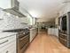 Open kitchen with stainless steel appliances, marble countertops, and hardwood floors, perfect for entertaining and daily living at 124 Canterbury Ln, Matthews, NC 28104