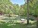 Scenic pond view with a small dock and fountain features surrounded by trees at 124 Canterbury Ln, Matthews, NC 28104