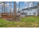 Exterior view of a white two-story home showcasing a large backyard with a deck and screened-in porch at 125 High Sail Ct, Mooresville, NC 28117