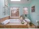 A bathroom featuring a soaking tub, toilet, large window and tiled floors and walls at 125 High Sail Ct, Mooresville, NC 28117