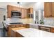 A bright kitchen features wood cabinets, subway tile backsplash, granite countertops, stainless steel appliances, and an island at 125 High Sail Ct, Mooresville, NC 28117