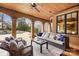 Relaxing covered patio with ceiling fan, plush seating, and views of the inviting pool area at 1312 Lookout Cir, Waxhaw, NC 28173