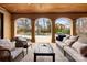 Inviting covered patio with comfortable seating, ceiling fan, and views of the landscaped backyard and pool at 1312 Lookout Cir, Waxhaw, NC 28173