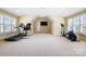 Large exercise room featuring three windows with shutters and exercise equipment including treadmill, elliptical, and inversion table at 1312 Lookout Cir, Waxhaw, NC 28173