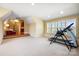 Bright exercise room with a treadmill and inversion table with windows and a view to a sitting area at 1312 Lookout Cir, Waxhaw, NC 28173