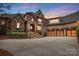 Beautifully lit home with stone and brick facade, showcasing the garage and driveway at 1312 Lookout Cir, Waxhaw, NC 28173