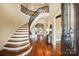 Elegant foyer features a curved staircase, hardwood floors, and open access to living spaces at 1312 Lookout Cir, Waxhaw, NC 28173