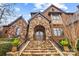 Grand stone staircase leads to an elegant double door entrance with lush landscaping at 1312 Lookout Cir, Waxhaw, NC 28173