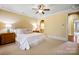 Spacious main bedroom with neutral colors, a ceiling fan, and an ensuite bathroom with arched entry at 1312 Lookout Cir, Waxhaw, NC 28173