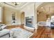 Sitting area with a fireplace, open to the bedroom with a chandelier, columns, and hardwood floors at 1312 Lookout Cir, Waxhaw, NC 28173