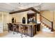 Beautiful basement bar with wood details, pendant lights, counter seating, and granite countertops at 1312 Lookout Cir, Waxhaw, NC 28173