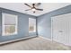Blue bedroom featuring two windows, a ceiling fan, and a closet at 137 Hunters Hill Dr, Statesville, NC 28677
