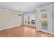 Open dining room featuring hardwood floors, a modern chandelier, and a decorative front door at 137 Hunters Hill Dr, Statesville, NC 28677
