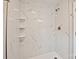 The renovated bathroom showcases a stylish marble tile shower with modern fixtures and ample space at 1404 Nottingham Rd, Kannapolis, NC 28081