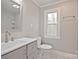 This bathroom features a new vanity, modern fixtures, and a window that provides ample natural lighting at 1404 Nottingham Rd, Kannapolis, NC 28081
