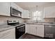 Bright kitchen featuring stainless steel appliances, white cabinets, and granite countertops at 1404 Nottingham Rd, Kannapolis, NC 28081