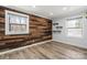 Stylish bedroom featuring unique wood accent wall, hardwood floors, and natural light at 1536 Plyler Lake Rd, Gastonia, NC 28054