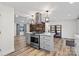 Open-concept living area with wood-look floors, modern kitchen island, and wood accent wall at 1536 Plyler Lake Rd, Gastonia, NC 28054