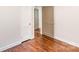 Bedroom with hardwood flooring, white walls, and multiple doors in neutral tones at 1831 Jameston Dr, Charlotte, NC 28209