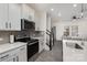 Well-lit kitchen boasts stainless steel appliances, sleek countertops, white cabinets and a view into a cozy living space at 2004 Crooked Oak Ln, York, SC 29745