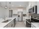 A kitchen featuring stainless steel appliances, white cabinets, gray backsplash and countertops, and modern lighting fixtures at 2004 Crooked Oak Ln, York, SC 29745