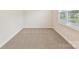 A cozy bedroom features neutral carpet flooring and a large window to the outside at 2615 Brentwood Pl, Charlotte, NC 28208