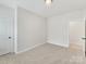 A spacious bedroom features neutral carpet flooring, a window and a closet door at 2615 Brentwood Pl, Charlotte, NC 28208