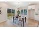 Modern dining area with a sleek dark table and a sliding door leading to an outdoor deck at 2615 Brentwood Pl, Charlotte, NC 28208