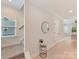 Inviting hallway featuring light wood floors, neutral walls, and a decorative table with a mirror at 2615 Brentwood Pl, Charlotte, NC 28208