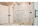 Bathroom featuring large glass enclosed shower with marble tile, black hardware, and white painted door at 2622 Old Camden Rd, Monroe, NC 28110