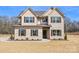 Two story home features a light colored brick, covered porch, with shutters, and an expansive lawn at 2622 Old Camden Rd, Monroe, NC 28110