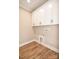 A clean laundry room features sleek white cabinets and stylish wood-look flooring at 2622 Old Camden Rd, Monroe, NC 28110
