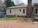 Back exterior of the house featuring neutral siding, a brick foundation and functional air conditioning unit at 303 Ellenwood Dr, Albemarle, NC 28001