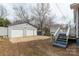 View of the back yard featuring the two-car garage, and a small deck with stairs at 305 Flat Rock St, Clover, SC 29710
