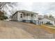 A single-story home featuring simple, light gray siding and a gravel driveway at 305 Flat Rock St, Clover, SC 29710