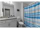 Bright bathroom featuring a vanity with granite countertop and a shower with blue striped curtain at 333 Dudley Dr, Fort Mill, SC 29715