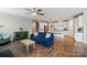 Open living room featuring hardwood floors, ceiling fan, and a view of the modern kitchen at 333 Dudley Dr, Fort Mill, SC 29715