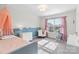 Stylized bedroom with a soft blue bed, a fun wall decor, and natural light at 3439 Duchess Ave, Fort Mill, SC 29707