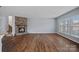 Open living room with hardwood floors, a stone fireplace, and a view of the backyard at 3439 Duchess Ave, Fort Mill, SC 29707