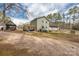 Wide view of backyard with gravel, showing deck, home's siding, and well-manicured yard at 360 Patience Dr, Concord, NC 28025