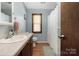 Bright bathroom with a light-colored vanity, a framed mirror, a toilet, a window with blinds, and a shower with curtain at 360 Patience Dr, Concord, NC 28025