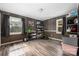 Versatile bonus room with wood-paneled walls, wood-look floors, large windows, and ample shelf storage at 360 Patience Dr, Concord, NC 28025